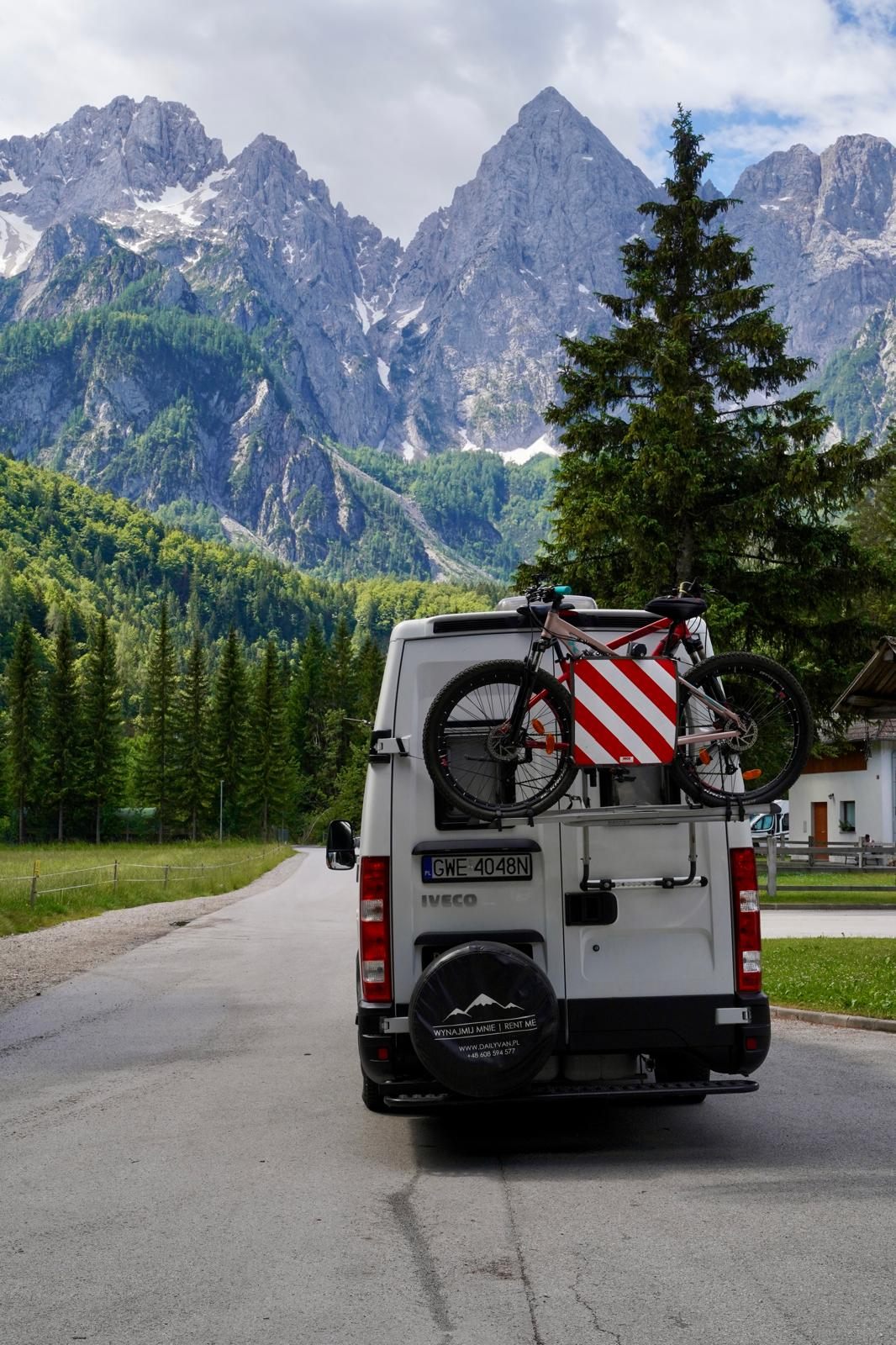 Iveco Daily z rowerem na bagażniku na tle ośnieżonych gór