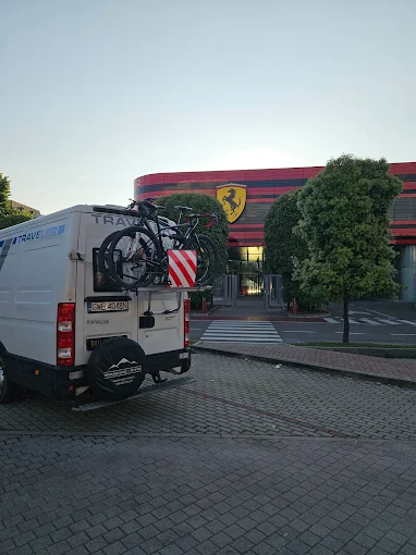 Kamper DailyVan nad jeziorem z rowerami na bagażniku i rozłożoną markizą